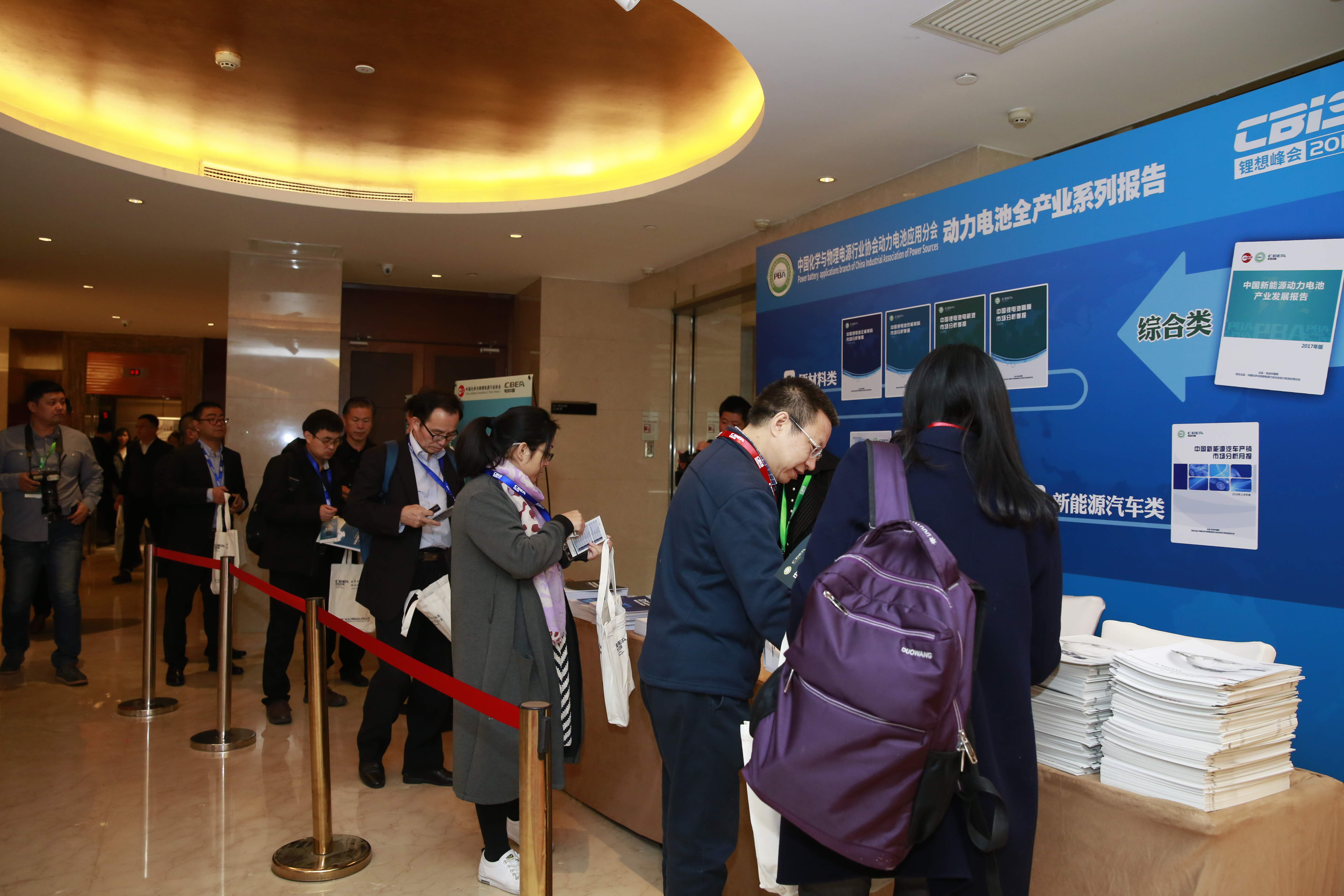 圖為參會嘉賓正在排隊領取動力電池應用分會提供的行業研究報告